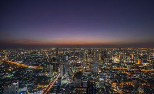 High angle view of illuminated cityscape against sky at night