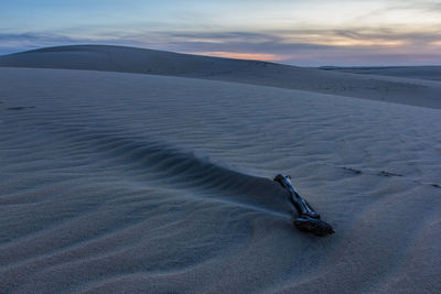 Scenic view of sand dunes against sky