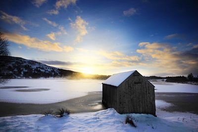 Built structure on snow covered landscape against sky