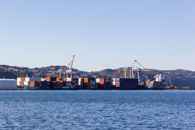 Commercial dock by sea against clear sky