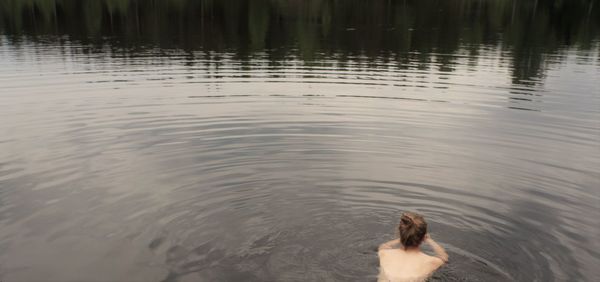 Rear view of topless woman in lake