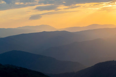 Scenic view of silhouette mountains against sky during sunset