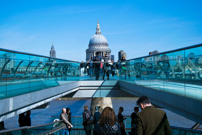 People on london millennium footbridge in front of st paul cathedral against sky