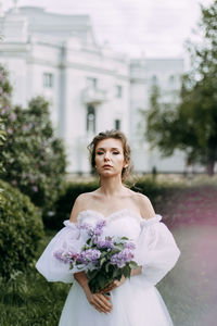 Portrait of woman standing against white wall