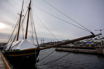 Sailboats moored in sea against sky