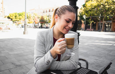 Young woman drinking coffee at cafe