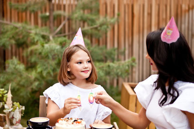 Portrait of happy girl holding ice cream on table
