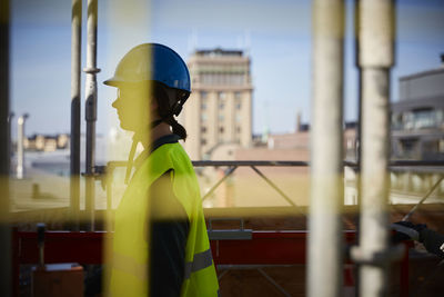 Side view of female architect at construction site