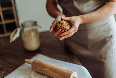 Woman preparing dough for rolling, crop on hands