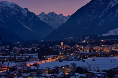 Illuminated cityscape against sky at dusk