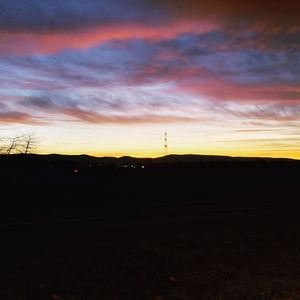 Scenic view of silhouette landscape against orange sky