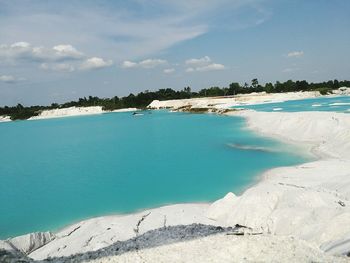 Scenic view of beach against cloudy sky