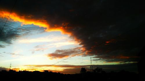 Silhouette of trees against dramatic sky