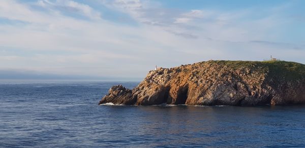 Scenic view of rock formation in sea against sky