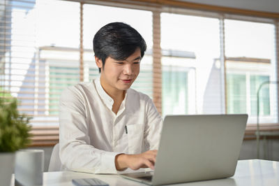 Businesswoman using laptop at home