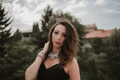 Portrait of woman standing against trees