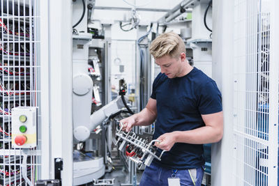 Man holding electronic component in modern factory