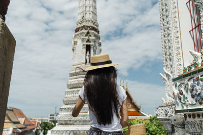 Rear view of woman standing against temple