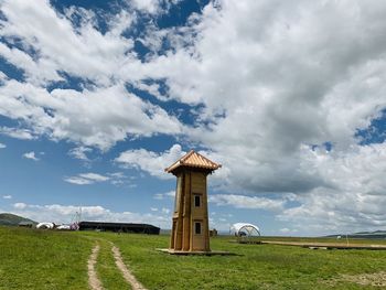 Built structure on field against sky