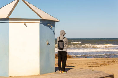 Man standing on beach against clear sky