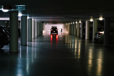 Man walking on illuminated corridor of building