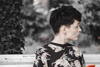 Portrait of young man looking away outdoors