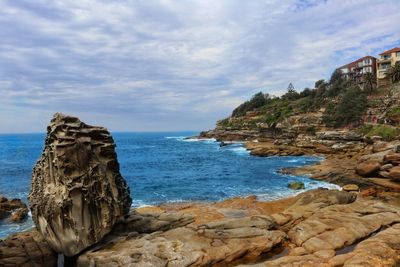 Rock formation on beach against sky