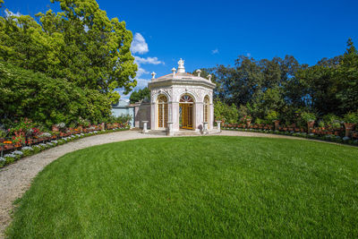 Lawn in front of building against blue sky