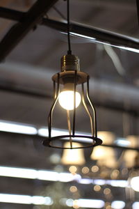 Low angle view of illuminated pendant light hanging from ceiling