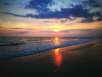 Scenic view of sea against dramatic sky during sunset