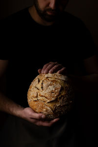 Midsection of man holding bread