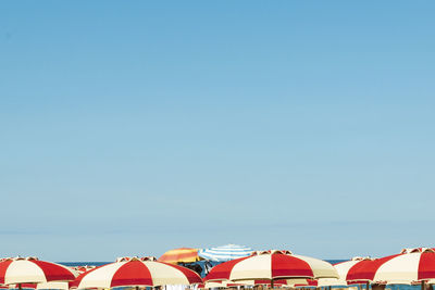 Beach umbrellas against clear blue sky