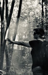 Rear view of woman standing in forest