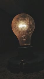 Close-up of illuminated light bulb against black background