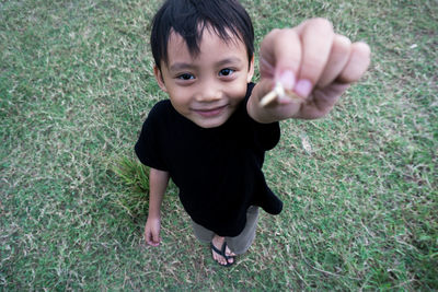 Portrait of boy standing on grassy field