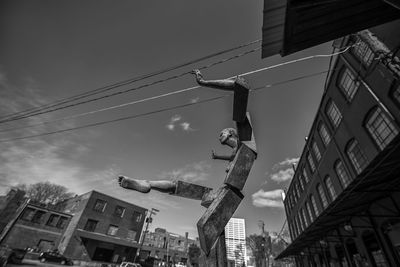 Low angle view of statue and buildings against sky