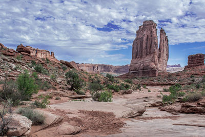 Rock formations on landscape against cloudy sky