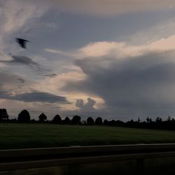 Scenic view of field against cloudy sky