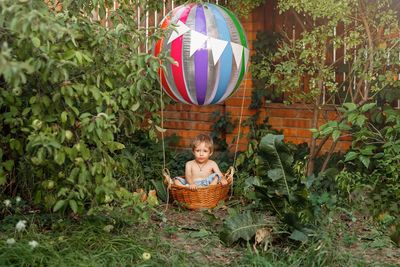 Full length of a boy sitting in basket