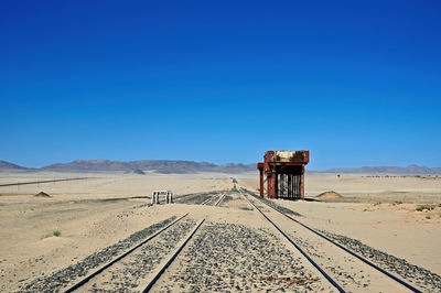 Scenic view of desert against clear blue sky