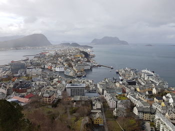 High angle view of townscape by sea against sky