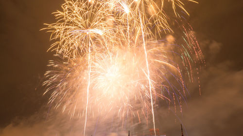 Low angle view of firework display at night