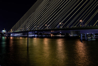 Illuminated bridge over river at night