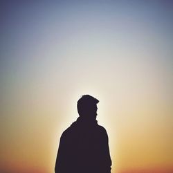 Rear view of silhouette man standing against sky during sunset