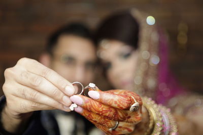 Close-up of couple holding wedding rings in hand