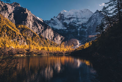 Scenic view of lake by mountains against sky during winter