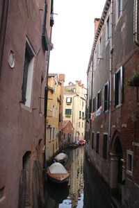 Canal amidst buildings against clear sky