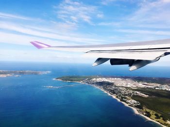 Airplane flying over sea against sky