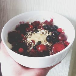 Close-up of hand holding bowl of food