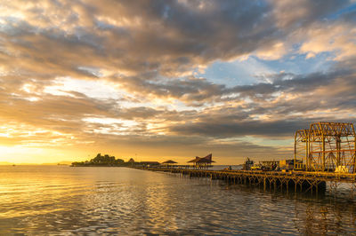 Scenic view of river against sky at sunset